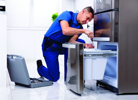 Refrigerator repair technician working